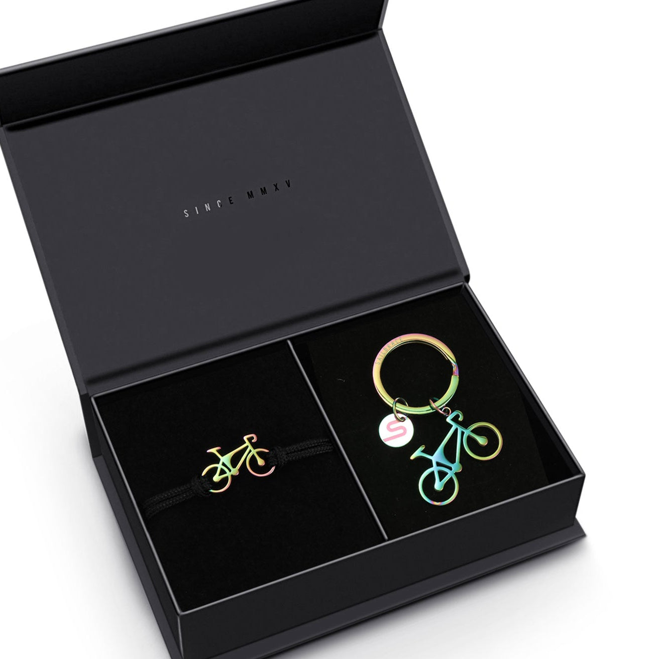 A black gift box opened to display an Everglow Road Bike Bracelet and a Road Bike Keychain, both featuring a minimalist design with green and gold colors on the bike figures.